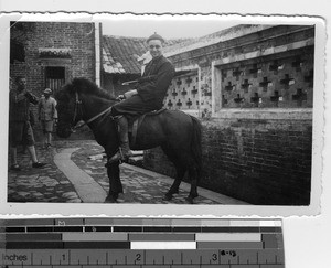 A Maryknoll priest riding a horse at Luoding, China, 1935