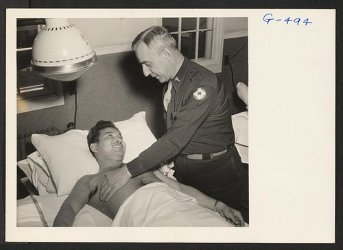 Pfc. James Oshiro being examined by Major Rotherwell in charge of physio-therapy at Moore General Hospital, Swannanoa, North Carolina. Pvt