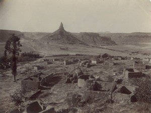 The Qiloane peak behind a village in ruins