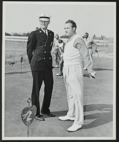 Bob Hope with unidentified fireman (Chief?) on a putting green