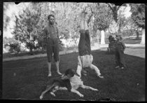 Three children playing in yard with dog