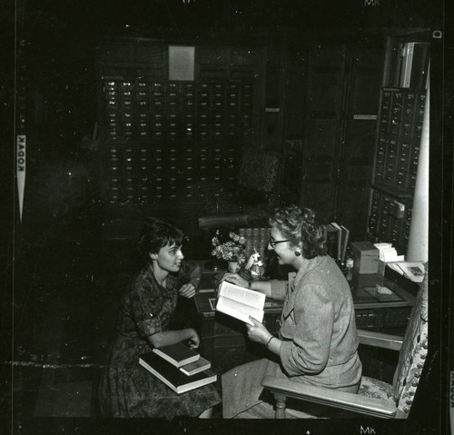 Dorothy Drake reads to a student librarian in Denison Library, Scripps College