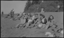 Large group sitting on the beach, circa 1922
