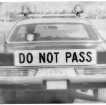 Caption reads: "Highway patrol cars lead with the 'do not pass' sign on the road in San Joaquin County in the first of the season's Operation Fogbound to help guide motorists in the heavy fog."