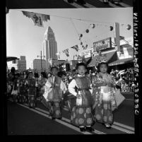 Children from Los Angeles Buddhist Federation in traditional dress walking in Los Angeles Nisei Week parade, 1965