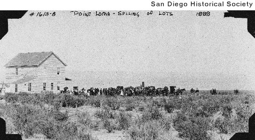 Distant view of people gathered near a house in Point Loma for a real estate auction
