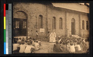 Missionary father teaching children their catechism, Congo, ca.1920-1940