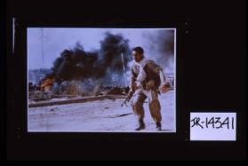 Poster depicting Iranian soldier running past flames