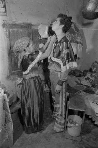 Woman dressing a man for the Carnival, Barranquilla, Colombia, 1977