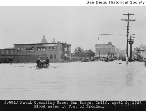 Group of people in a rowboat at the foot of Broadway during a flood