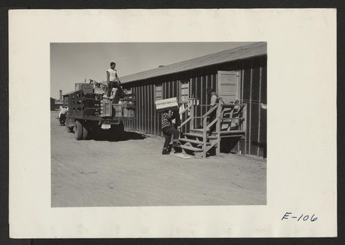 Crates of personal belongings shipped from Assembly Centers being delivered to permanent duration residents in this relocation center. Photographer: Parker, Tom Heart Mountain, Wyoming