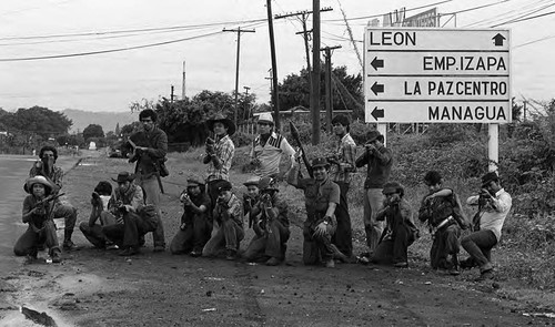 Sandinistas pose in front of a road sign, Nicaragua, 1979