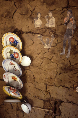 Photographs and dishes hanging from a wall, San Basilio de Palenque, 1976