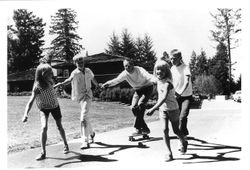 Charles S. Schulz, the world-famous Peanuts cartoonist, being pulled on a skateboard by four of his five children near their Coffee Lane home west of Sebastopol, California, about 1960