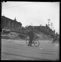 Man with bicycle surveying earthquake damage