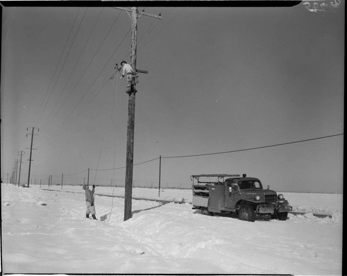 Linemen working on pole in snow