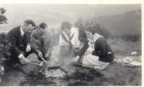 Harold Elliott with two women around a campfire