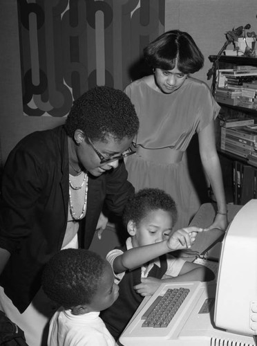 Yolanda Parker watching children learn with a computer, Los Angeles, 1983