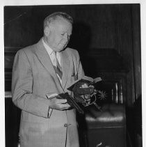 Postmaster General Arthur E. Summerfield examines some of the artifacts used by the Pony Express riders