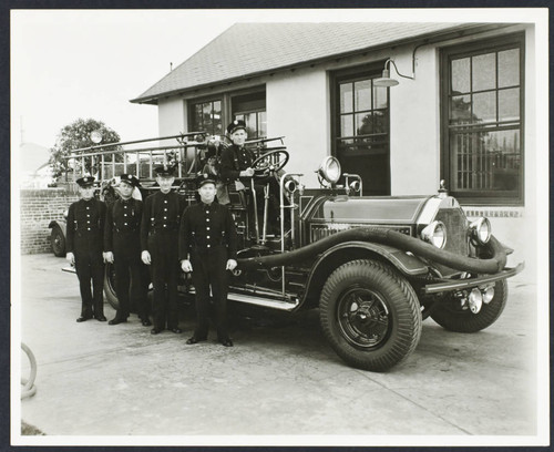 Crew stands alongside fire engine in front of Fire Station No. 10, 1445 Peterson Avenue