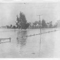Copy Print: View of a flood scene during the "Edwards Break" in the levee near the Pocket area of Sacramento. This view is of St. Joseph's Catholic Cemetery on 21st Street