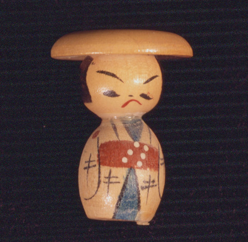 Kokeshi doll with angry look on its face