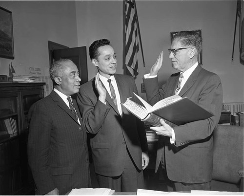 Elbert T. Hudson standing with Gilbert Lindsay as he is sworn in to the Police Commission, Los Angeles, 1963