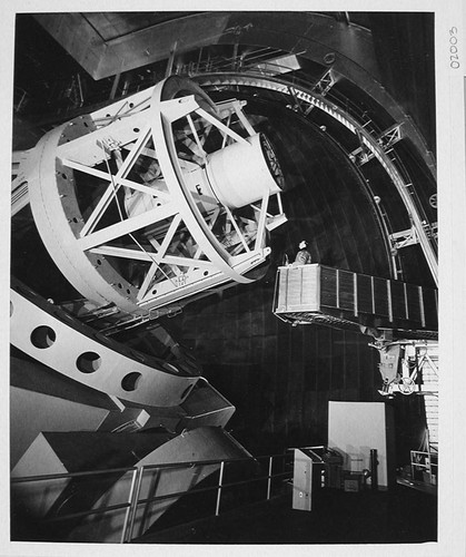 Observer riding the elevating platform to the prime focus cage of the 200-inch telescope, Palomar Observatory