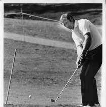 Bob Lunn, pro golfer, chips a ball onto the green