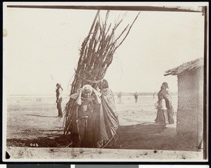 Mojave Indian woman carrying a bundle of wood for the cremation of an Indian Chief
