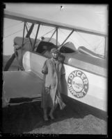 Armless pilot Josephine Callaghan standing in front bi-plane at Dycer airport, 1929