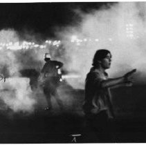 View of the riots held at the California State Fair grounds in 1971. Police encounter young people at the front gate of Cal Expo