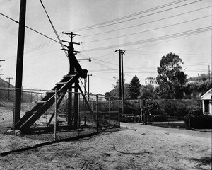 One of six oil wells off Chavez Ravine road is shown in operation, pointing up the issue raised by opponents to the city's baseball plans, 1957