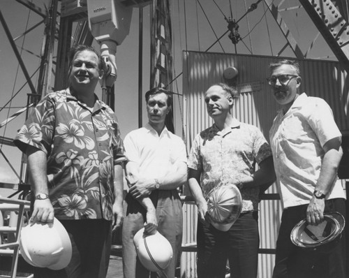 Two Russian scientists, Valeriy A. Krasheninnikov, second from left, a paleontologist from the Academy of Science in Moscow, and Alezander P. Lisitzen, second from right, a geologist from the Institute of Oceanology, also in Moscow, were members of the Deep Sea Drilling Project Sixth Leg scientific team. They were welcomed aboard in Honolulu by Bruce C. Heezen, left of Columbia University, and Alfred G. Fischer, right of Princeton University. Heezen and Fischer were Co-Chief Scientists for the Honolulu to Guam leg which ended on August 5. Part of the 194-foot-tall derrick and other associated drilling and equipment is visible on the drilling floor of the Challenger. 1969