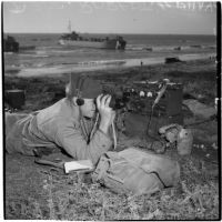Soldier looking through binoculars during the Army-Navy maneuvers off the coast of Southern California in late 1946