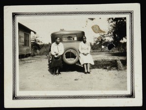 Bobbie Dunn & an unidentified person sitting on a car bumper, Page Normal School, Texas