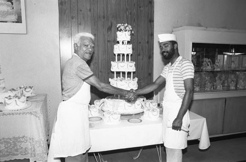 Jimmy Davis and his son posing in their bakery, Los Angeles, 1987