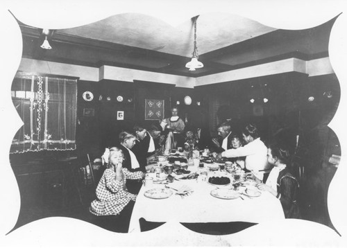 Michael Eltiste family seated at dining table in the Fiene home, Orange, California