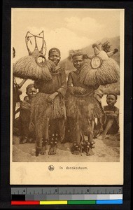 Dancers wearing costumes and holding masks, Congo, ca.1920-1940