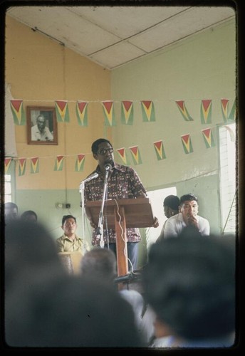 Man speaking with Guyanese flags