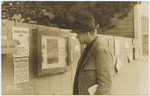 [Man looking at notices on fence in Carmel]