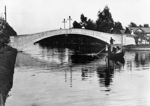 Gondola passing under canal bridge