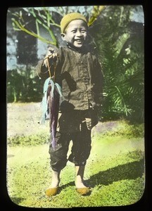 Smiling child holding fish, China, ca. 1918-1938