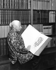 Marta Feuchtwanger holding an open copy of the Nuremberg Chronicle from 1493 (for LA Times), ca. 1975-1985