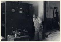 Man in overalls, with large radio panel
