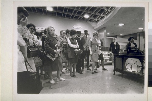 Shocked people in Emporium watch television reports of Kennedy's assasination