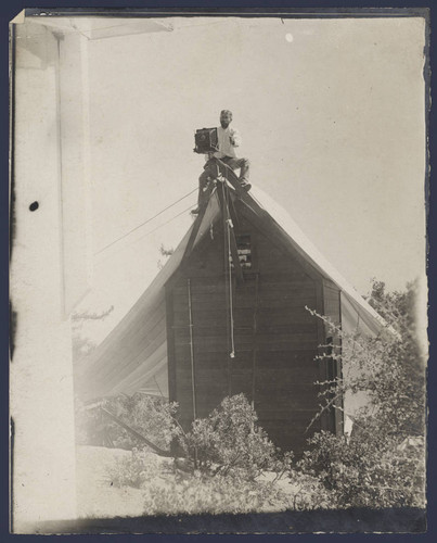 Ferdinand Ellerman, with portrait camera, perched on top of the Smithsonian spectrobolometer shed on Mount Wilson