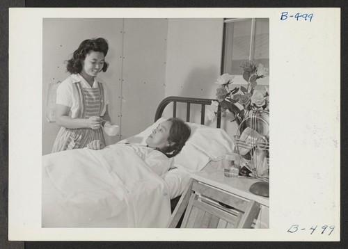 Nurse's Aid student Cheiko Neeno attends Mrs. Hide Uyeda, a patient in the Poston Hospital. Photographer: Stewart, Francis Poston, Arizona