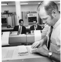 Caption reads: "Crime Tracker--Larry Riggs, foreground checks over computer cards during a test operation of the new California Law Enforcement Telecommunications System (CLETS)."