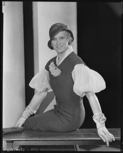 Peggy Hamilton modeling a fitted dress, a hat and embroidered gloves, circa 1931-1933